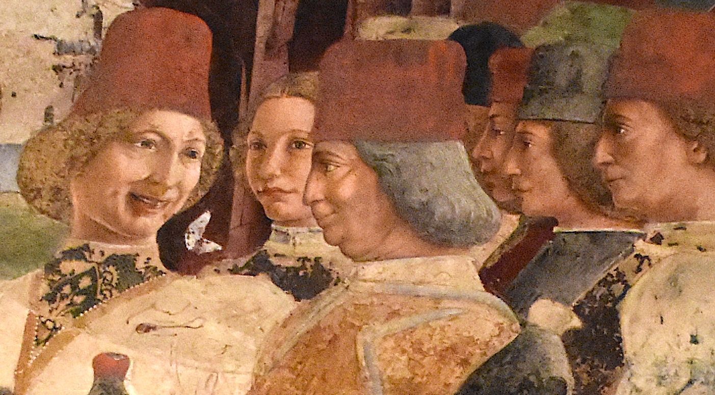 Gros plan de fresque : six visages d’hommes coiffés de bonnets rouges, l’un sourit, les autres sont de profil.